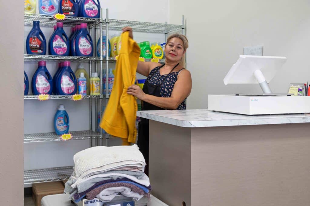 Fluff and Fold Sun Valley – laundry drop-off counter with staff folding clothes at Burbank Wash & Dry.